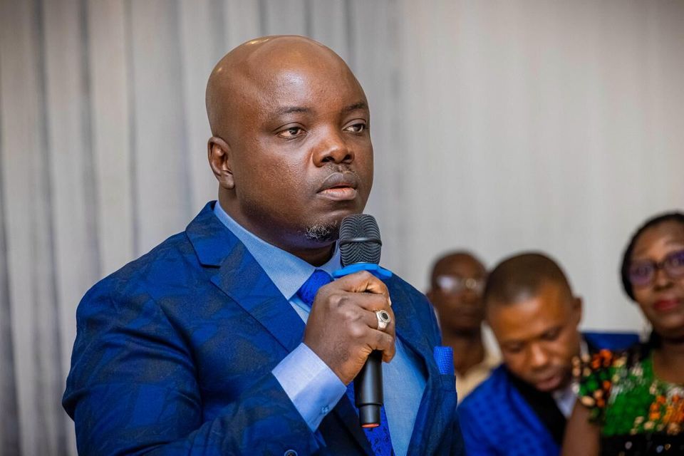 Kenechukwu Nwosu speaking into a microphone at an event