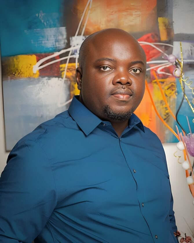 Kenechukwu Nwosu in a blue shirt in front of an abstract painting