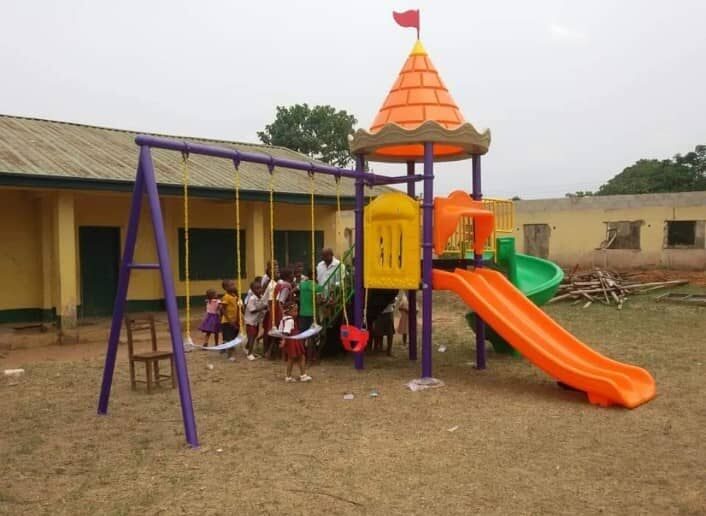 Pupils on new playground equipment beside a classroom block